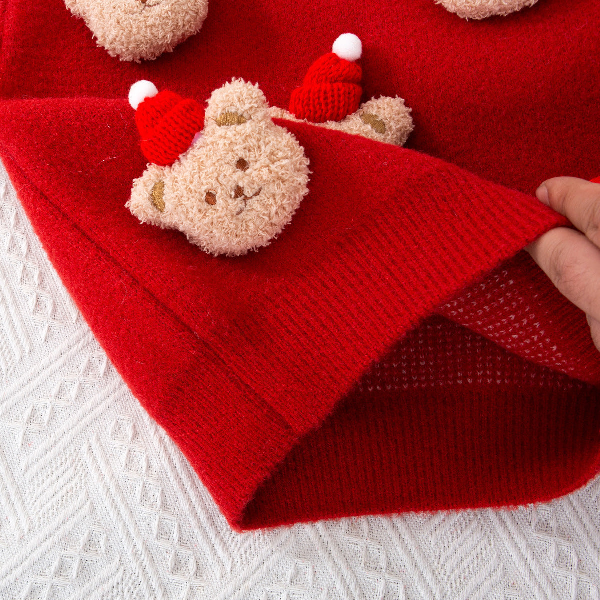 クマの刺繍が施された子供用厚手ニットのクローズアップ