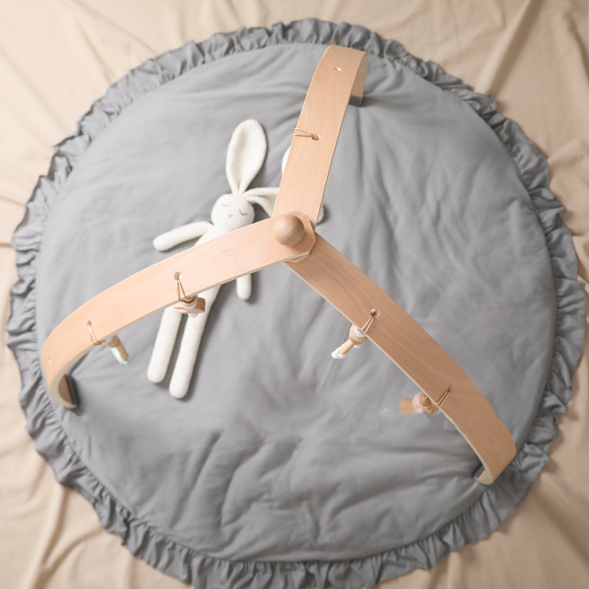 front view of minimalist wooden baby gym with hanging toys