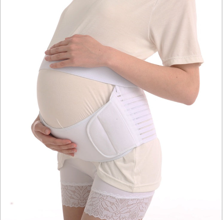 Close-up of pregnant belly with maternity support belt showing soft fabric texture