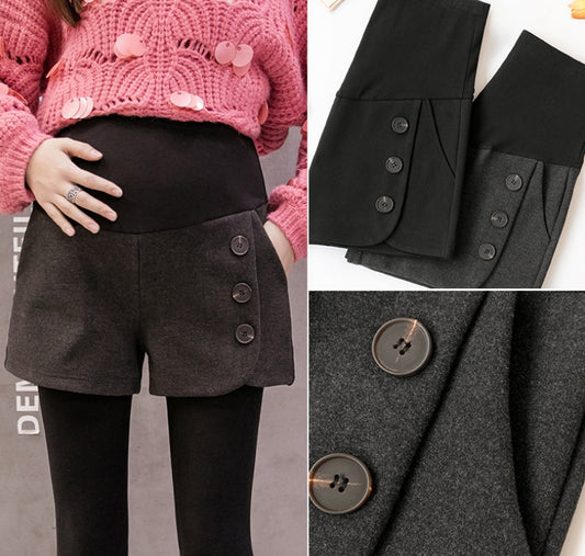 ピンクのニットとグレーのマタニティショートパンツを着た女性
