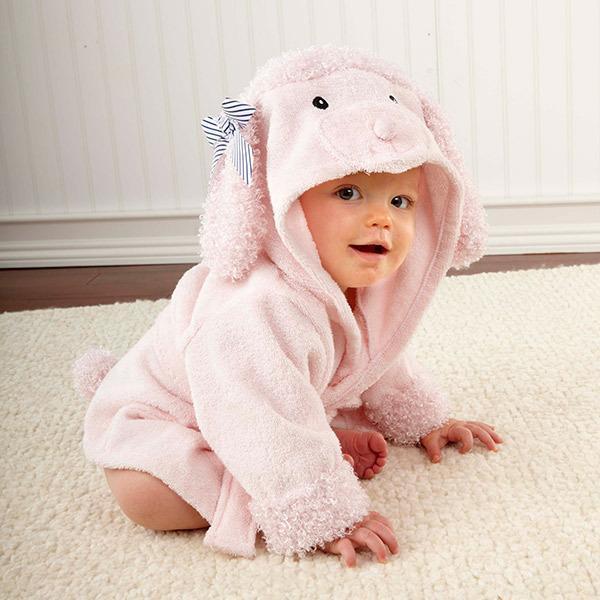 toddler wearing hooded cloak style bathrobe on white bedding
