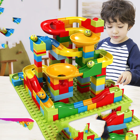 子どもが小粒のビルディングブロックで玉転がしコースを組み立てている様子
